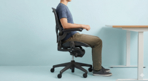 Correct sitting posture with neutral elbows, grounded feet, and straight spine at the desk
