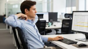 Incorrect armrest height showing shoulders shrugged upward and elbows pushed outward during desk work